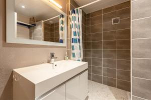 a bathroom with a white sink and a shower at Appartement T2 Les Pyrénées in Bagnères-de-Bigorre +12 photos