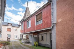 a red brick building with a church steeple at Appartement T2 Les Pyrénées in Bagnères-de-Bigorre
