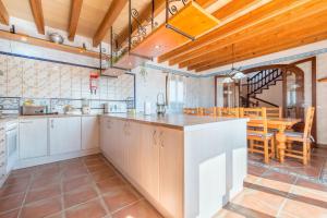 a kitchen with white cabinets and a dining room at Can Pedro - Sa Torre Nova in Son Carrió
