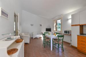 a kitchen and dining room with a table and chairs at Appartamento La Spiga in Procchio +12 photos