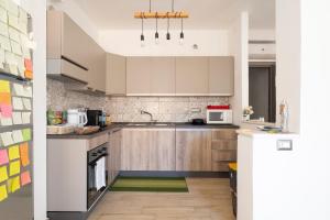 a kitchen with white cabinets and a green rug at Affittacamere Da Riccardo in Jerzu