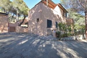 a large white house with a driveway at Appartamento La Spiga in Procchio