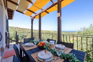 a table on a balcony with a view of the ocean at Casale- Il Giglio Rosa in Sorso