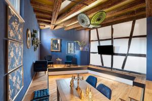 a living room with blue walls and a table and chairs at Remise im Wolkensteiner Hof in Gernsbach