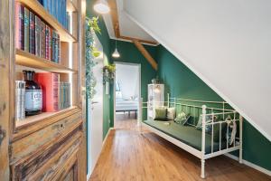 a room with green walls and a staircase with bookshelves at Remise im Wolkensteiner Hof in Gernsbach