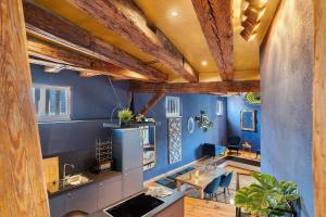 a kitchen with blue walls and wooden beams at Remise im Wolkensteiner Hof in Gernsbach