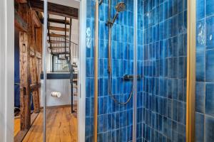 a bathroom with a shower with blue tiles at Remise im Wolkensteiner Hof in Gernsbach +31 photos