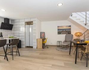 a living room with a table and chairs and a staircase at Casa da Madou in Setúbal