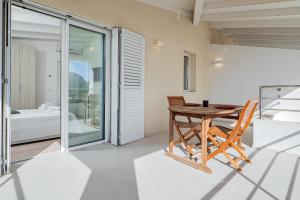 a table and chairs in a room with a balcony at Villa Cormorani 1 in Golfo Aranci