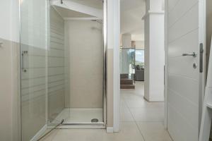 a shower in a bathroom with a glass door at Villa Cormorani 1 in Golfo Aranci +30 photos