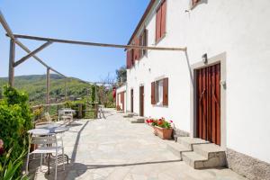 a patio with a table and chairs and a building at Monolocale Fattorialmare Viola in Camogli