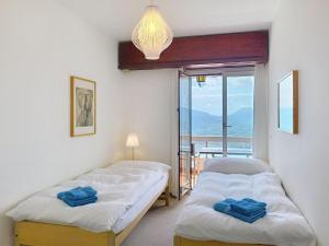 two beds in a room with a view of the ocean at Apartment Superpanorama II by Interhome in Lugano
