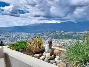a statue sitting on a ledge with a view of a city at Apartment Superpanorama II by Interhome in Lugano