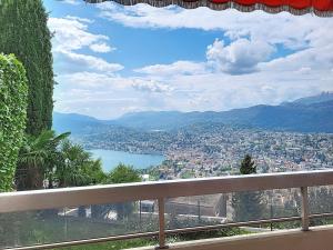 a view of a city and a lake from a balcony at Apartment Superpanorama II by Interhome in Lugano +9 photos