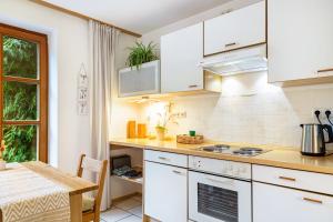 a kitchen with white cabinets and a table at Ferienwohnung Schatzlmayr in Vilshofen an der Donau