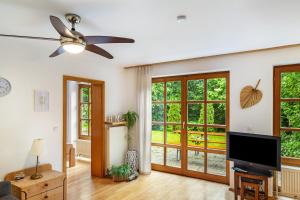 a living room with a ceiling fan and a television at Ferienwohnung Schatzlmayr in Vilshofen an der Donau