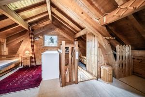 an attic room with wooden walls and a refrigerator at Chalet 6p Classique-Les Ajoncs d'or in Verchaix