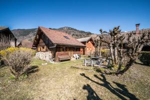 a log cabin with a bench in a yard at Chalet 6p Classique-Les Ajoncs d'or in Verchaix