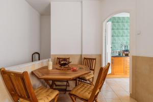 a dining room with a wooden table and chairs at Duplexdubocage in Setúbal