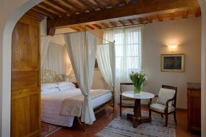 a hotel room with a bed, table and chairs at Villa Olmi Firenze in Florence