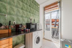 a kitchen with a washing machine and a window at Duplexdubocage in Setúbal