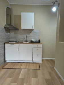 a kitchen with white cabinets and a sink at RHouse in Rho