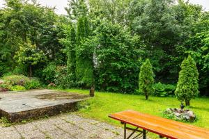 a wooden bench in a garden with trees and grass at Ferienwohnung Schatzlmayr in Vilshofen an der Donau