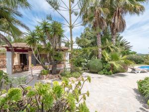 a resort with palm trees and a swimming pool at Sa Barraca in Santanyi