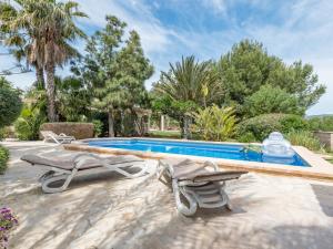 a swimming pool with two lounge chairs next to a swimming pool at Sa Barraca in Santanyi