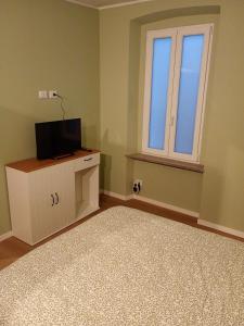 a room with a tv on a cabinet and a window at RHouse in Rho