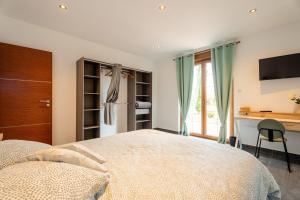 a bedroom with a bed and a desk and a television at La Perle Bleue proche Strasbourg in Hoerdt +29 photos