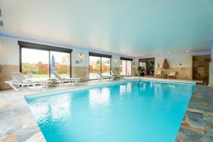 a large swimming pool with blue water in a house at La Perle Bleue proche Strasbourg in Hoerdt