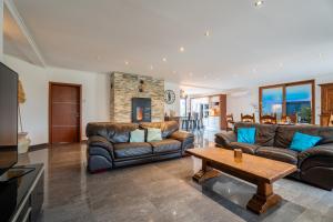 a living room with leather couches and a coffee table at La Perle Bleue proche Strasbourg in Hoerdt