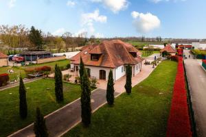 a house with a red roof on a green lawn at La Perle Bleue proche Strasbourg in Hoerdt