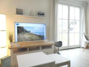 a living room with a flat screen tv on a wall at Haus Elve in Zierow