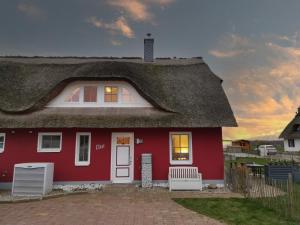 a red house with a thatched roof at Haus Elve in Zierow