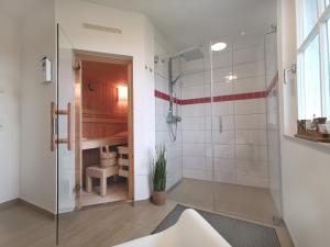 a bathroom with a shower with a glass door at Haus Elve in Zierow +22 photos
