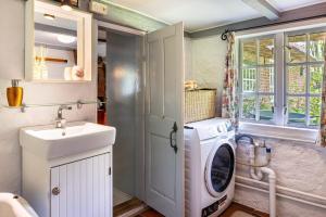 a laundry room with a washing machine and a sink at Reetdachhaus Bischoff in Kuden