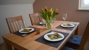 a wooden table with plates of food and wine glasses at Ferienwohnung Wilhelmshof in Sinzig