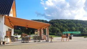a pavilion with tables and chairs on a patio at Ferienwohnung Wilhelmshof in Sinzig
