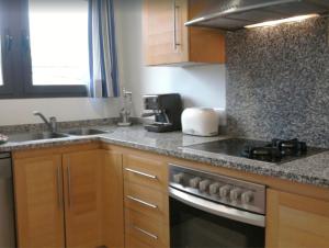 a kitchen with a sink and a stove top oven at Apartamento Llenaire in Pollença