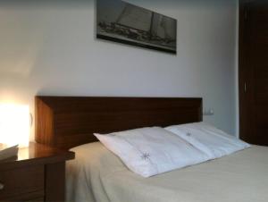 a bedroom with a bed with a wooden headboard at Apartamento Llenaire in Pollença
