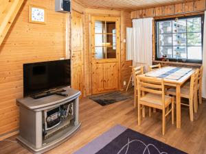 a living room with a television and a table with chairs at Holiday Home Kantapää d3 by Interhome in Luosto
