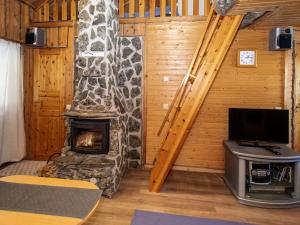 a living room with a fireplace in a log cabin at Holiday Home Kantapää d3 by Interhome in Luosto