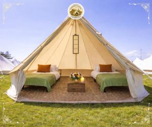 a teepee tent with two beds in the grass at Edinburgh Festival Glamping By Stay Social Stays in Edinburgh +23 photos