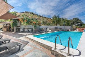 a swimming pool in a yard with a table and chairs at Casa Roque in Monachil