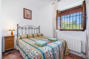 a bedroom with a bed and a window at Casa Roque in Monachil +27 photos