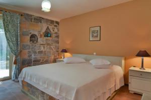 a bedroom with a large bed and a stone wall at Vitali River House Andros in Andros