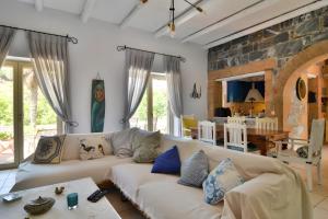 a living room with a white couch and a stone wall at Vitali River House Andros in Andros