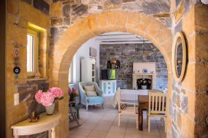 a kitchen and dining room with a stone wall at Vitali River House Andros in Andros